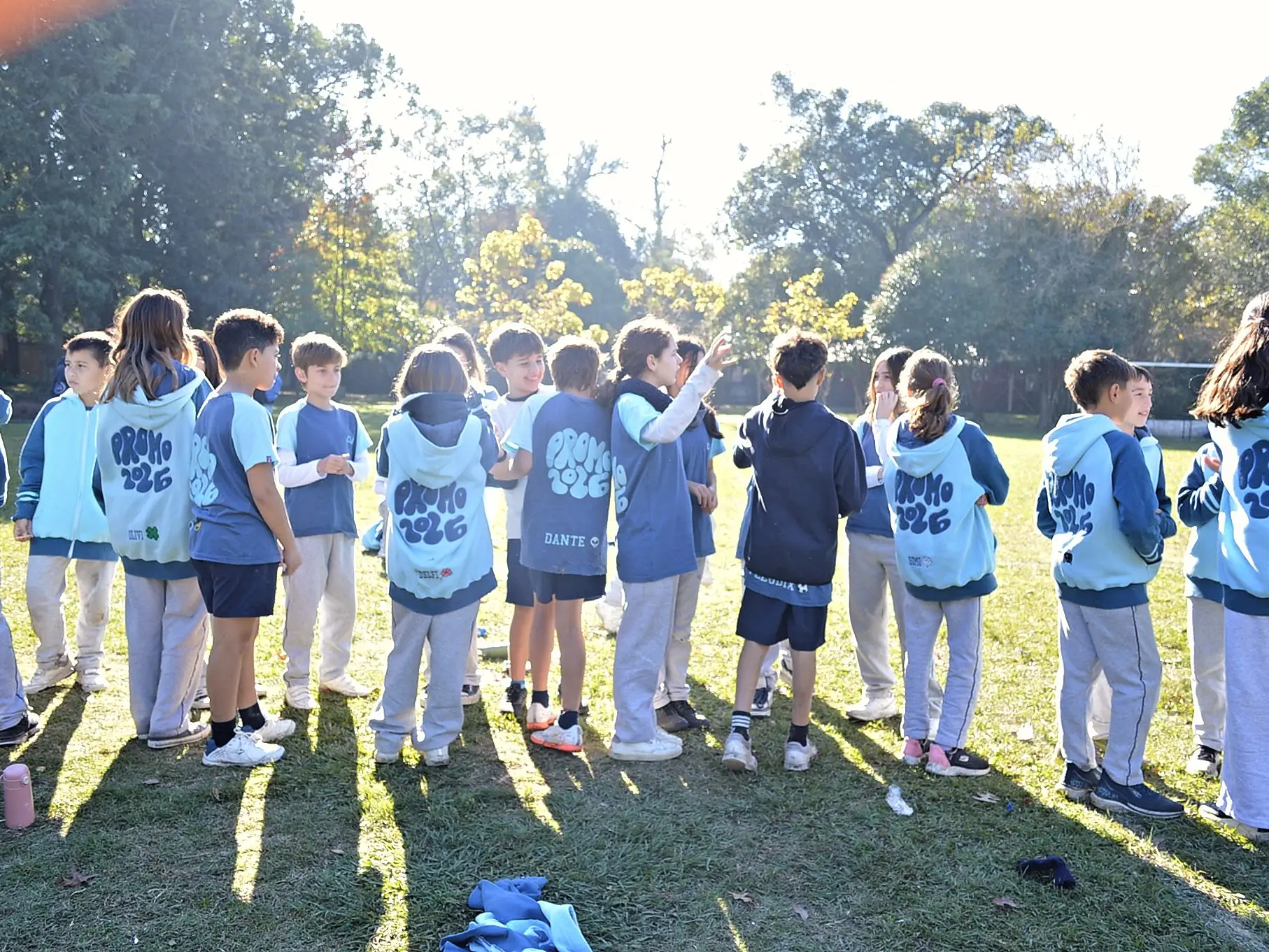 Alumnos con pecheras de las houses en ronda sobre el campo de deportes